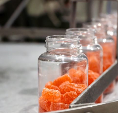 Vitamins supplements with gummy shape on the conveyor belt of the manufacturing industrial facility